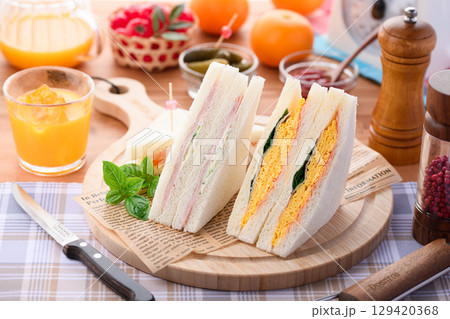 朝食やランチにぴったりのミックスサンドイッチとオレンジジュース　カフェ風おしゃれ盛り付け 129420368