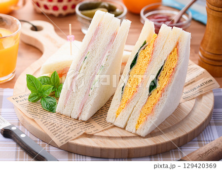 朝食やランチにぴったりのミックスサンドイッチとオレンジジュース　カフェ風おしゃれ盛り付け 129420369