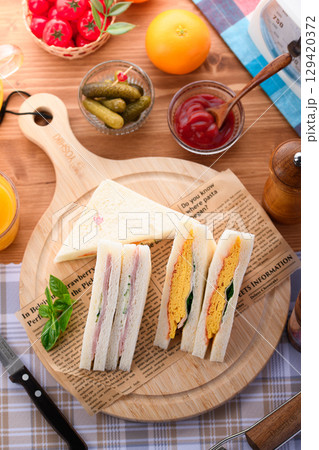 朝食やランチにぴったりのミックスサンドイッチとオレンジジュース　カフェ風おしゃれ盛り付け 129420372