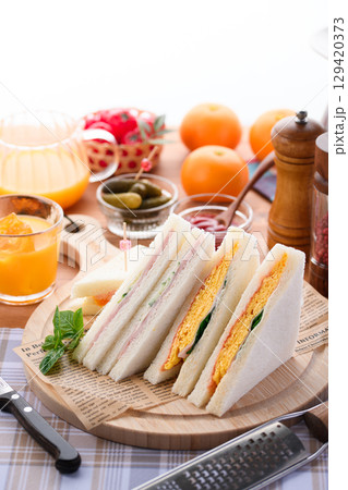 朝食やランチにぴったりのミックスサンドイッチとオレンジジュース カフェ風おしゃれ盛り付け 朝食やランチにぴったりのミックスサンドイッチとオレンジジュース カフェ風おしゃれ盛り付け 129420373