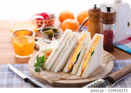 朝食やランチにぴったりのミックスサンドイッチとオレンジジュース　カフェ風おしゃれ盛り付け 129420375