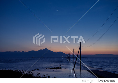 夕闇迫る長部田海床路と月 129420400