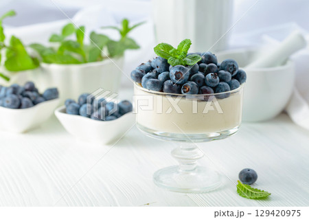 Mascarpone cream with fresh blueberries in a clear bowl. 129420975