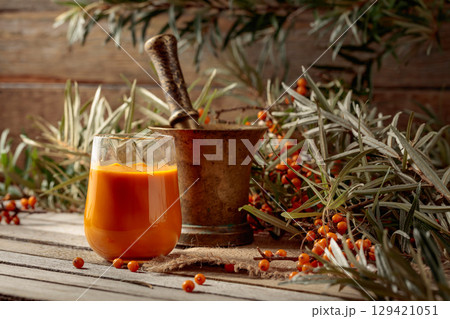 Glass of sea buckthorn juice with branches and fresh berries. Glass of sea buckthorn juice with branches and fresh berries. 129421051