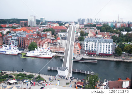 a rising bridge in Gdansk, with a heavy rain and stormy sky. This photo, perfect for a business or travel theme, captures the unique design and modern construction of the city 129421376