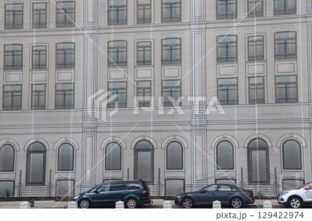 The building is covered with a construction curtain with a painted facade, The building is covered with a construction curtain with a painted facade, 129422974