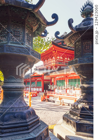 Bronze lanterns frame the view of vibrant red Kasugataisha Shrine in Nara Japan 129423060