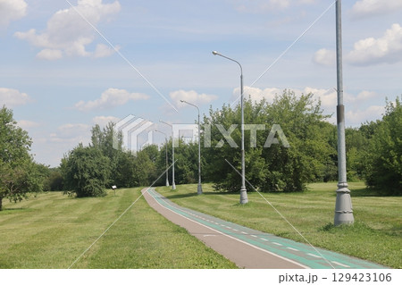 Asphalt paths in an open green landscape park, Kolomenskoye, August 2022. Asphalt paths in an open green landscape park, Kolomenskoye, August 2022. 129423106