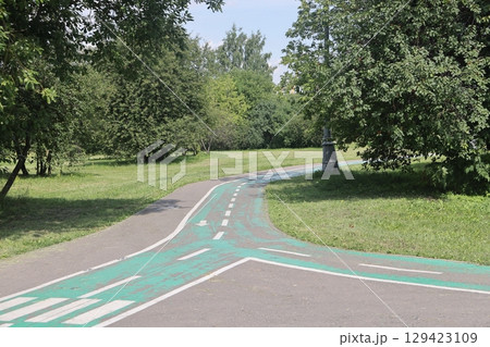 Asphalt paths in an open green landscape park, Kolomenskoye, August 2022. Asphalt paths in an open green landscape park, Kolomenskoye, August 2022. 129423109