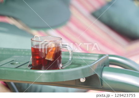 A cup of herbal tea in the country, a glass of tea on the country swing. A cup of herbal tea in the country, a glass of tea on the country swing. 129423755