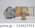 Banknote on the background of a crumpled piece of newspaper on a white background, 129423763