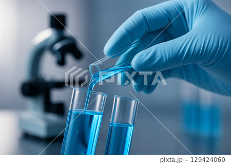 AI generated closeup of gloved hand pouring blue liquid between test tubes in a clean lab with microscope in background showing precision and sterile scientific work 129424060
