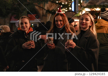 Friends with mulled wine at Munich Christmas market night Friends with mulled wine at Munich Christmas market night 129424165