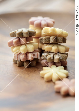 縦に積み上げたマーガレット型の紫芋とココアとプレーンクッキー 129424279