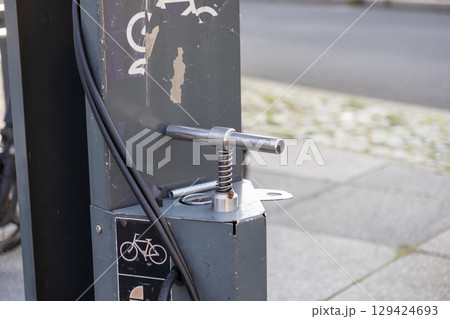 Public bicycle repair station with an air pump handle, promoting sustainable urban mobility and convenient city cycling maintenance 129424693