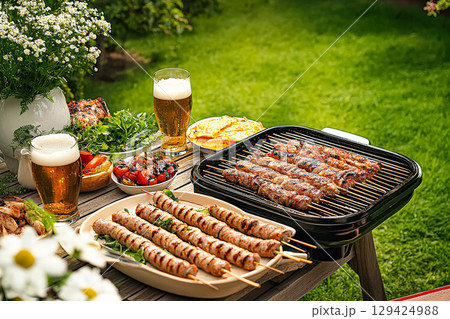 Barbecue with a variety of meats and vegetables, including skewers and a grill 129424988