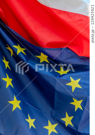 Poland, Polish flag and European flag on the facade of a building in Krakow. 129425921