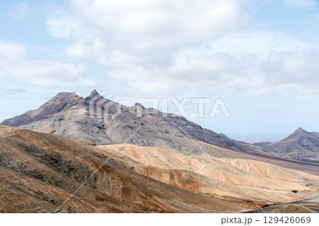 明るい日差しの下の荒涼として緑のない乾燥したはげた山々　フエルテベンテュラ島の内陸にて 129426069