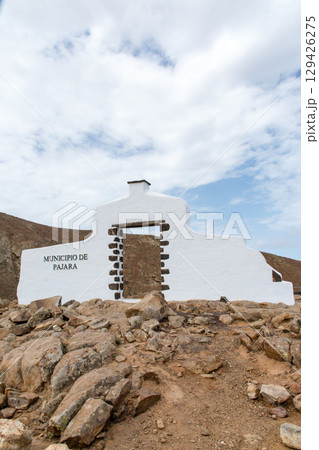 荒涼として緑のない乾燥したはげた山の上に建てられた白壁の建物 フエルテベンテュラ島のパハラへの入り口 荒涼として緑のない乾燥したはげた山の上に建てられた白壁の建物 フエルテベンテュラ島のパハラへの入り口 129426275