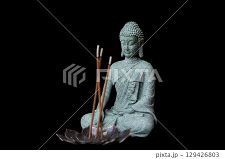buddha statue with incense sticks on black background buddha statue with incense sticks on black background 129426803