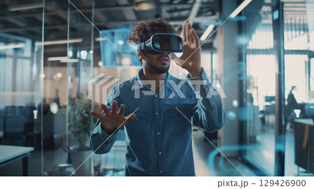 Business portrait corporate man in blue shirt, open office interactive holographic projections all around. wearing VR headset glasses. Reality using technology work. Concept using modern technology 129426900