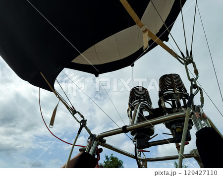Hot air balloon burners against cloudy sky on a scenic day 129427110