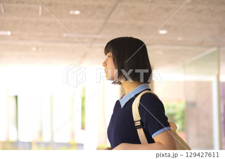 校内を歩くリュック姿の女子大学生 横顔 校内を歩くリュック姿の女子大学生 横顔 129427611