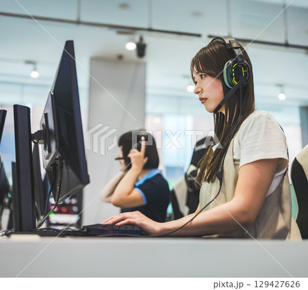 　ヘッドセットでオンライン対戦する女子大生 129427626