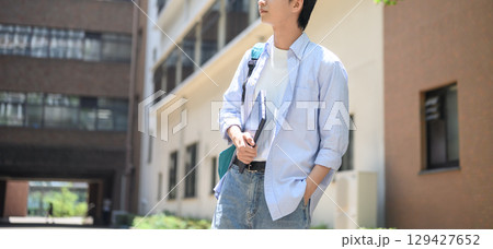 　キャンパスを歩く男性大学生のロングショット 129427652