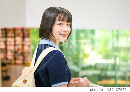 　図書館で振り向く女子学生 129427672