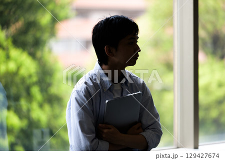 　影の中でたたずむ孤独な学生 129427674