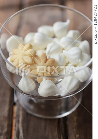 デザートガラスに入れたメレンゲクッキーとマーガレット型クッキー 129427721