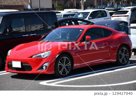 駐車場に並んだ赤いスポーツカー(トヨタ・86  初代) 129427840