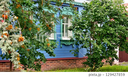 Beautiful wooden blue house with trees nearby. Beautiful wooden blue house with trees nearby. 129427859