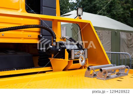 Tow truck winch on the platform for loading the transported vehicle. Tow truck platform with winch and hook with wheel stops. Safe loading of the vehicle on the tow truck 129428922