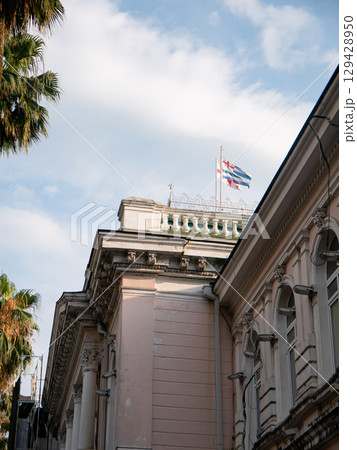 ジョージアの伝統的なピンクの建物と揺れる国旗 129428950