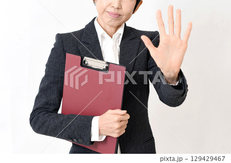 ストップのポーズするスーツ姿のミドル女性 129429467