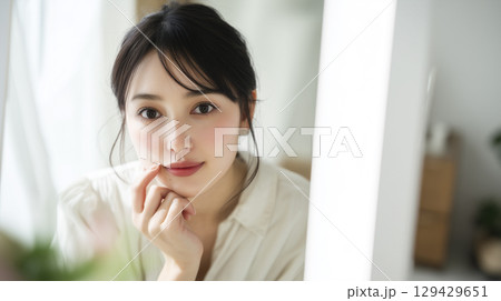 家を出る前にメイクの確認をする女性 129429651