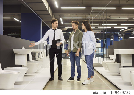 Couple looking at flush toilets while shopping for sanitary fixtures at plumbing store Couple looking at flush toilets while shopping for sanitary fixtures at plumbing store 129429787