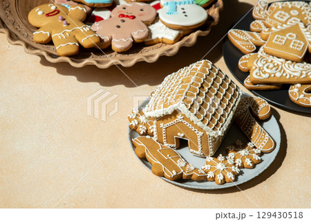 Gingerbread House and Cookies on table. Christmas food baking. Xmas sweets Gingerbread House and Cookies on table. Christmas food baking. Xmas sweets 129430518