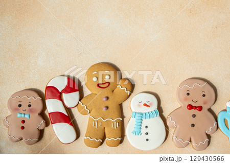 Gingerbread cookies with icing decoration. Christmas food. Gingerbread man snowman baking. Top view table. Xmas sweet copy space background 129430566