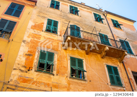 Yellow houses buildings. Monterosso Italian village. Windows with shutters narrow street balcony architecture, Liguria, Italy. Yellow houses buildings. Monterosso Italian village. Windows with shutters narrow street balcony architecture, Liguria, Italy. 129430648