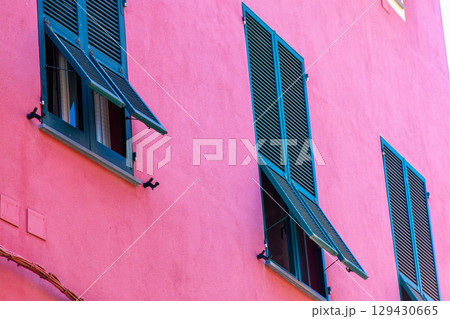 Green shutters on the windows. Pink houses buildings Italian village architecture Italy. Green shutters on the windows. Pink houses buildings Italian village architecture Italy. 129430665