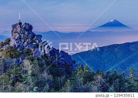 国師ヶ岳山頂から望む富士山と夜明けの街明かり 129430911