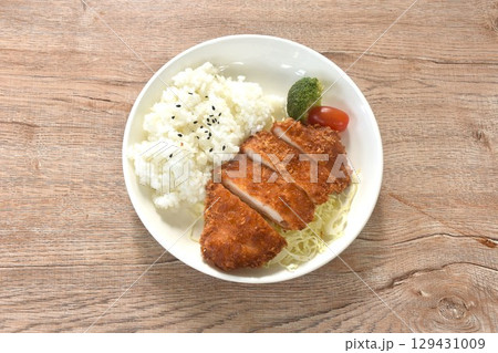 deep fried slice pork or tonkatsu with cabbage tomato and broccoli vegetable on black sesame rice in plate deep fried slice pork or tonkatsu with cabbage tomato and broccoli vegetable on black sesame rice in plate 129431009