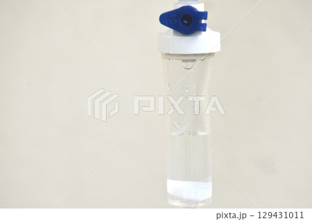 saline solution dropping and flowing to rubber tube on white background 129431011