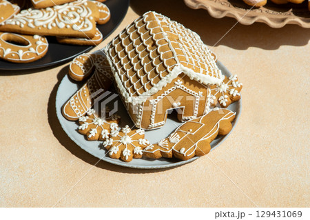 Decorated Gingerbread House and Cookies on table. Christmas food baking. Xmas sweets 129431069
