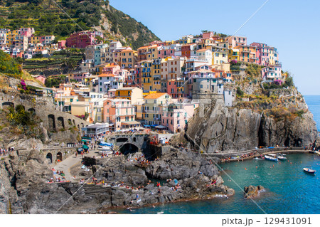 Colorful houses on cliff edge. Manarola Italian village Cinque Terre, Liguria, Italy. Summer sea 129431091