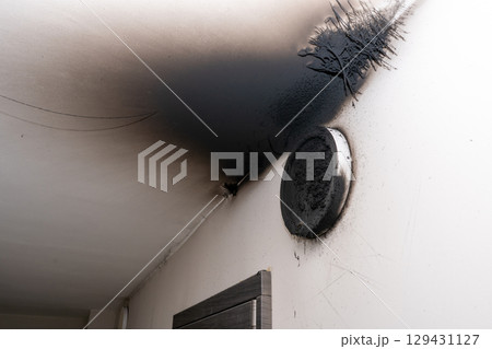 Burnt out LED lamp. A lampshade lamp on the wall after a fire. Spontaneous combustion and fire in a residential building. Burnt out LED lamp. A lampshade lamp on the wall after a fire. Spontaneous combustion and fire in a residential building. 129431127