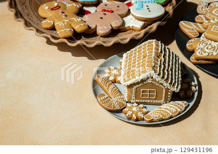 Decorated Gingerbread House and Cookies on table. Christmas food baking. Xmas sweets 129431196
